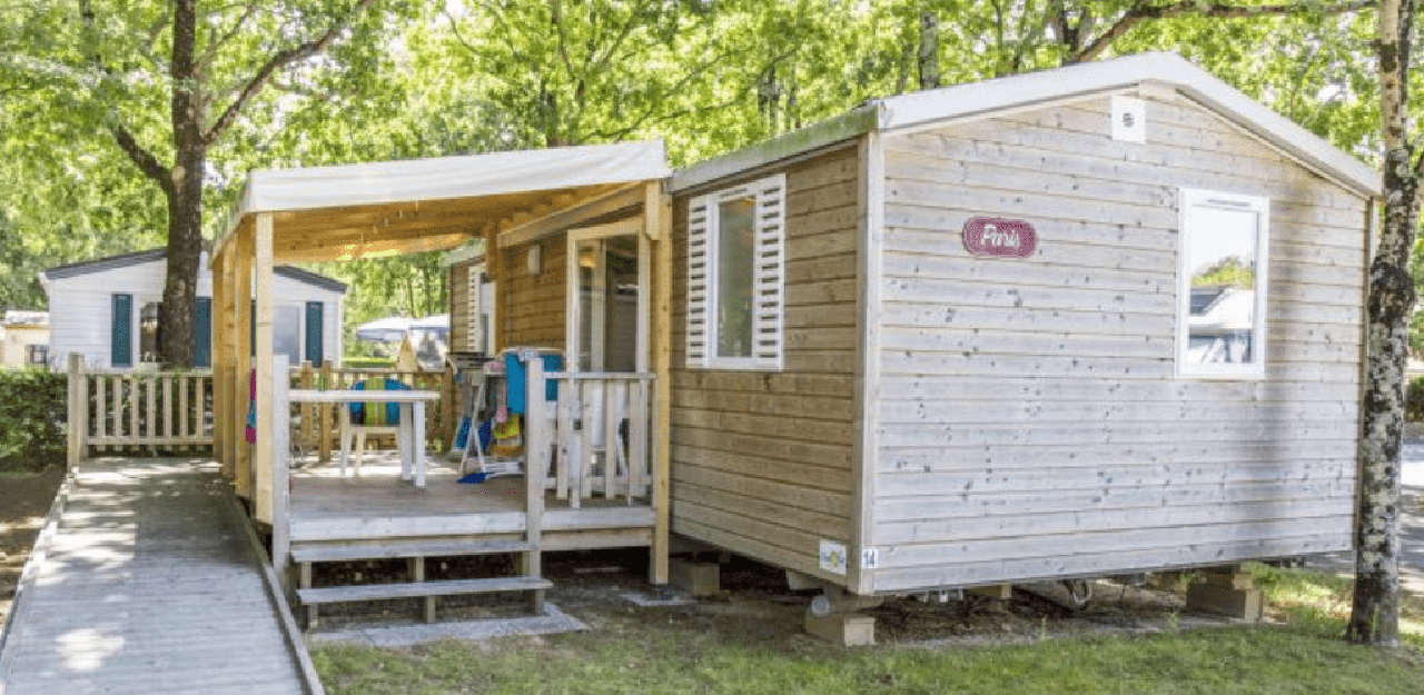 Buitenkant van een MIVA-stacaravan en zijn terras, te huur als kuurgast-accommodatie op camping Contrexéville in régio Grand-Est