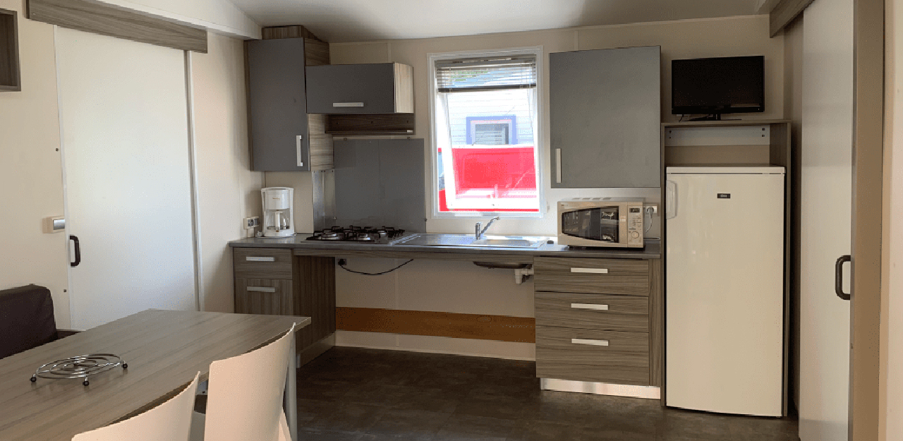 The kitchen area in the mobile home with reduced mobility access for spa visitors at the Contrexéville campsite in Vosges