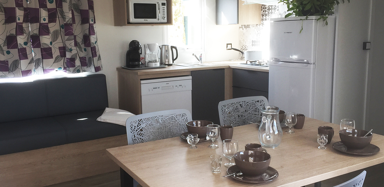 Interior of VIP mobile home with kitchen area and living room, rental accommodation for spa visitors in Vosges